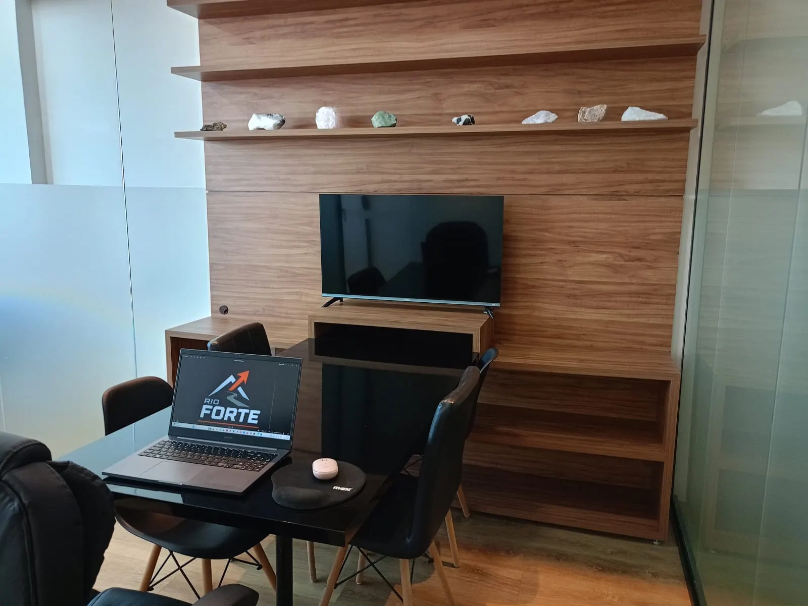 Sala de reunião da Rio Forte com mesa, notebook e TV