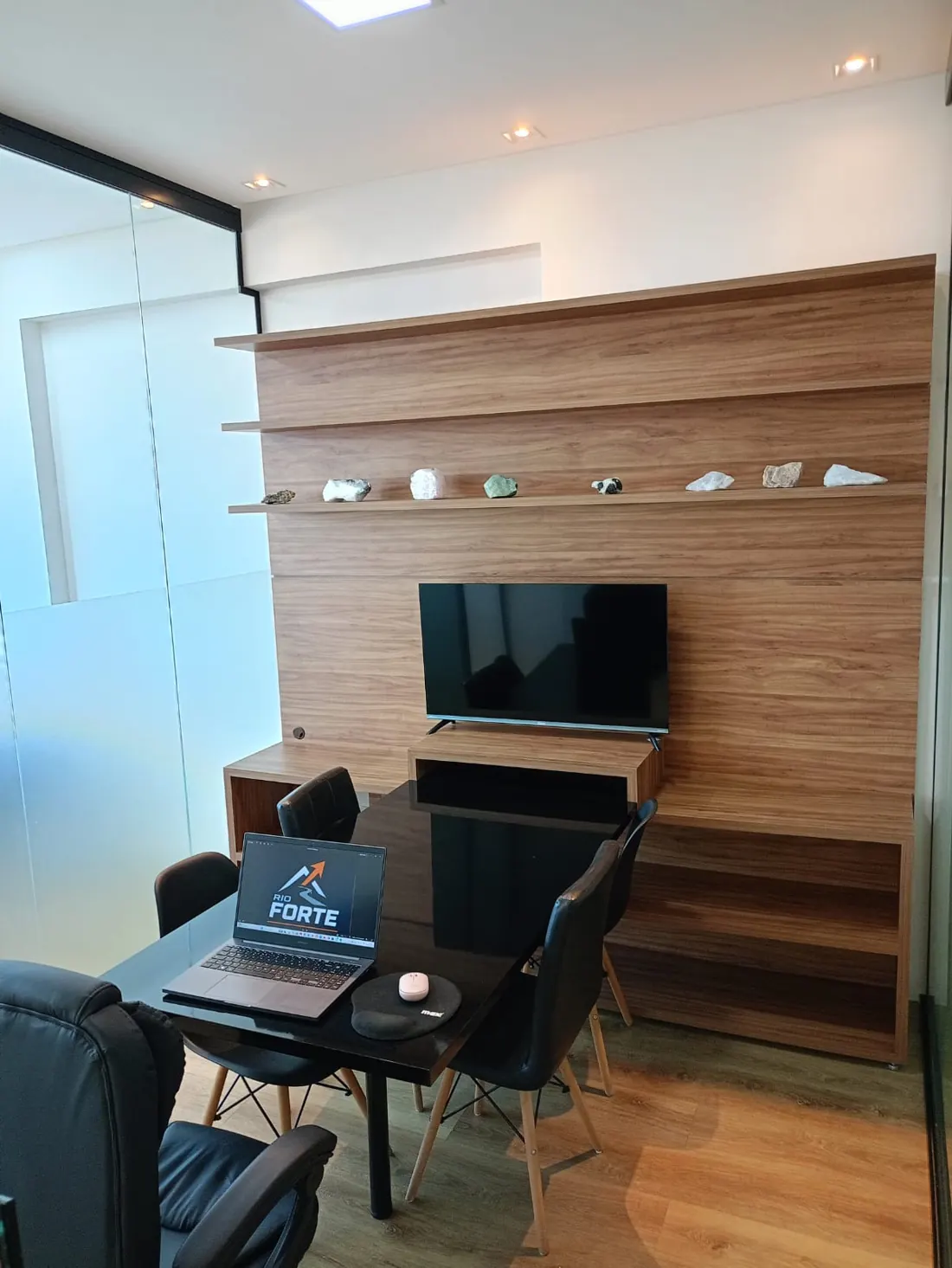 Mesa de reunião com notebook Rio Forte e painel de madeira com TV